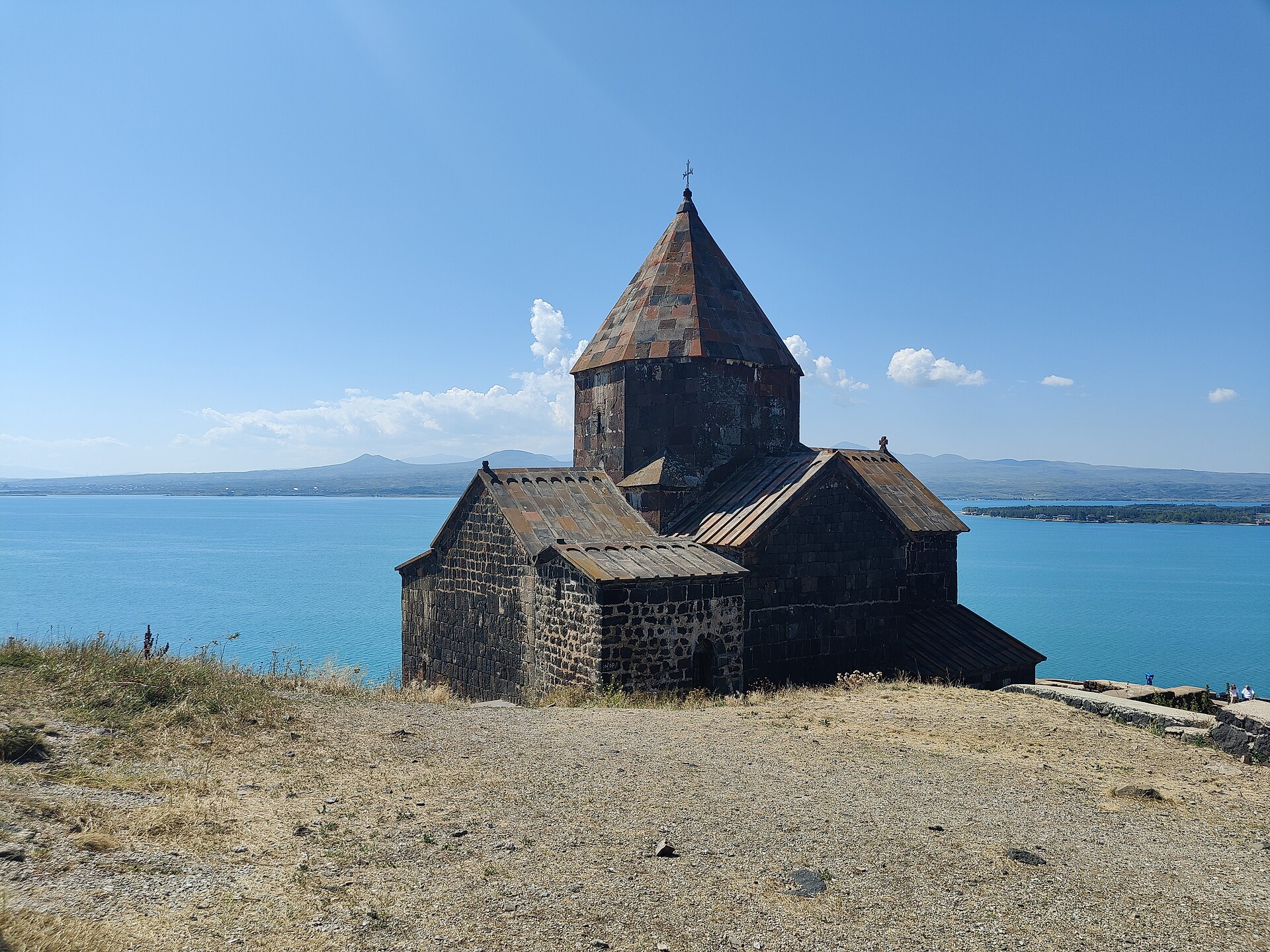 Sevanavank monastery on a peninsula in Lake Sevan, with mountains behind the water