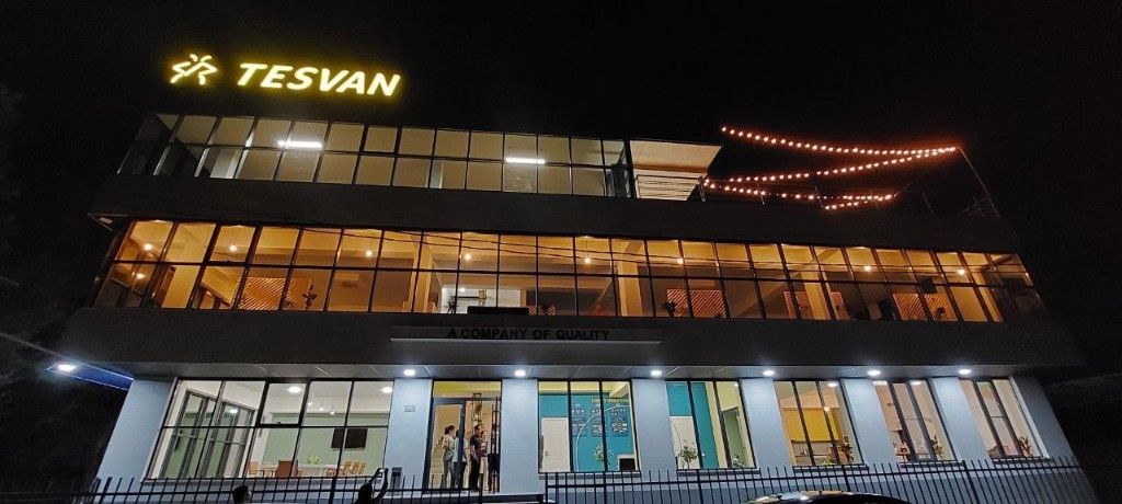The Tesvan building in Sevan at night, with the name lit above the glass floors